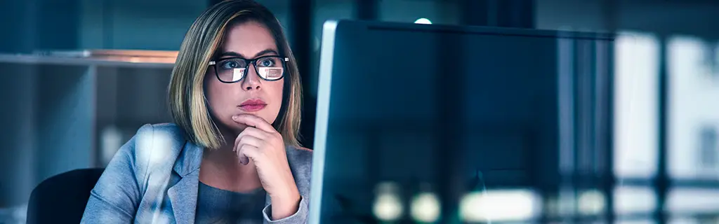 O que é nuvem pública e quando sua empresa deve investir nessa solução de TI? 1 mulher se indagando sobre algo que vê no computador